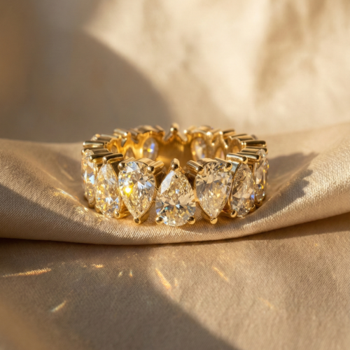 Alternating pear cut moissanite eternity band in 18k gold vermeil on silk background